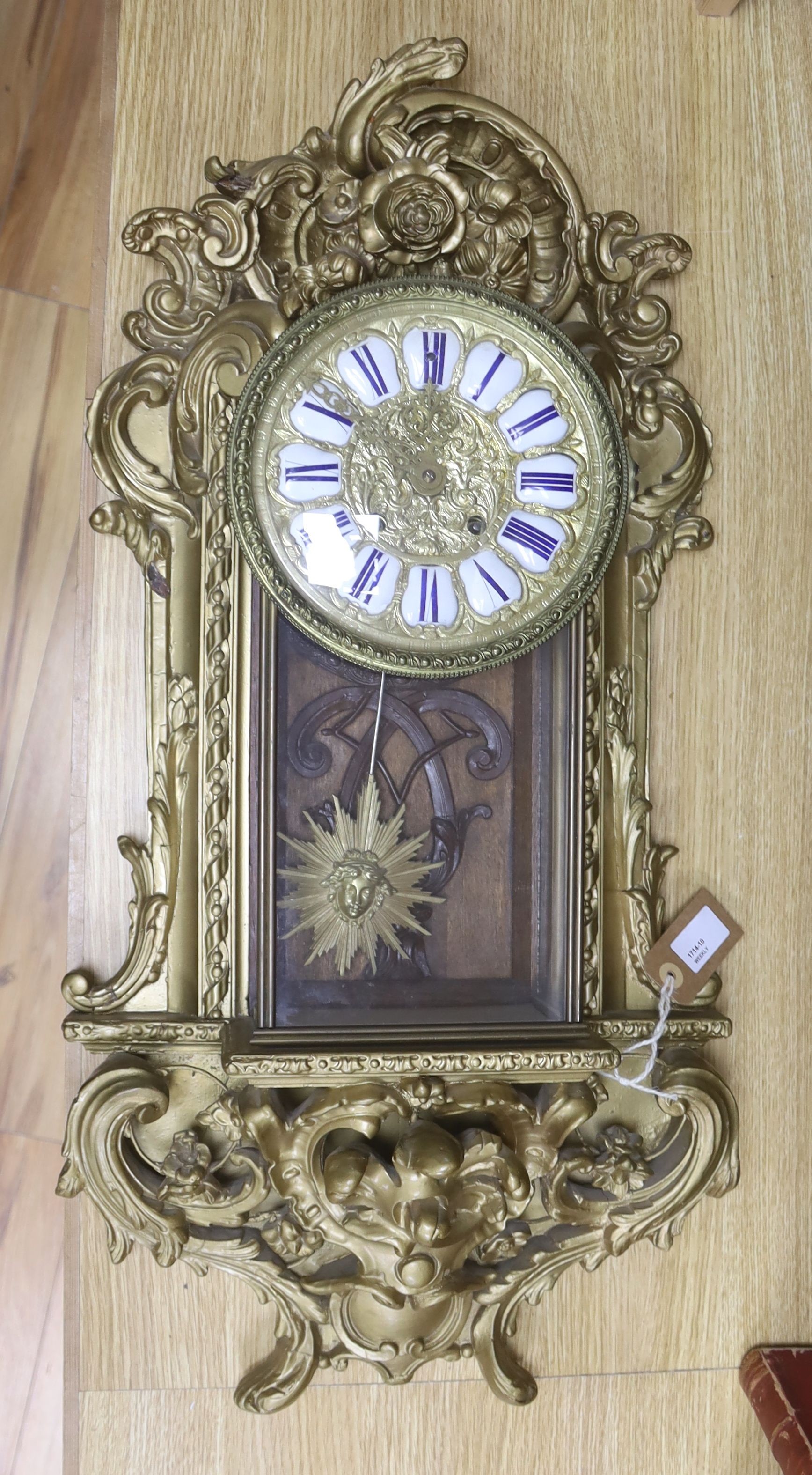 A 19th century French gilt and composition wall clock, with scrolled acanthus carving and 'sunburst' pendulum, 72cm high